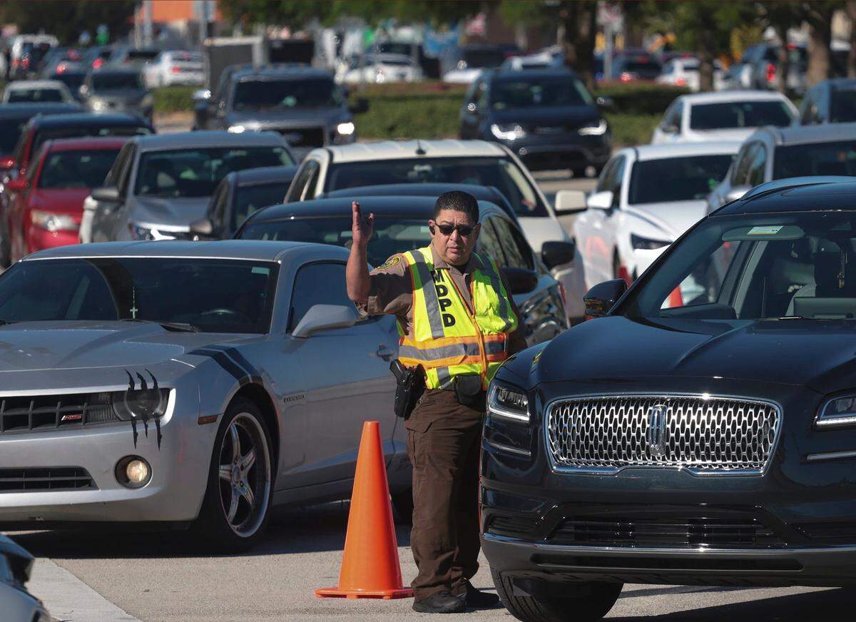 Se forman largas filas para las pruebas de detección y las vacunas de COVID-19 mientras la Policía de Miami-Dade mantiene el tráfico fluyendo dentro y fuera de Tropical Park, un sitio de vacunación y pruebas en el barrio de Westchester de Miami-Dades, el jueves 23 de diciembre de 2021.