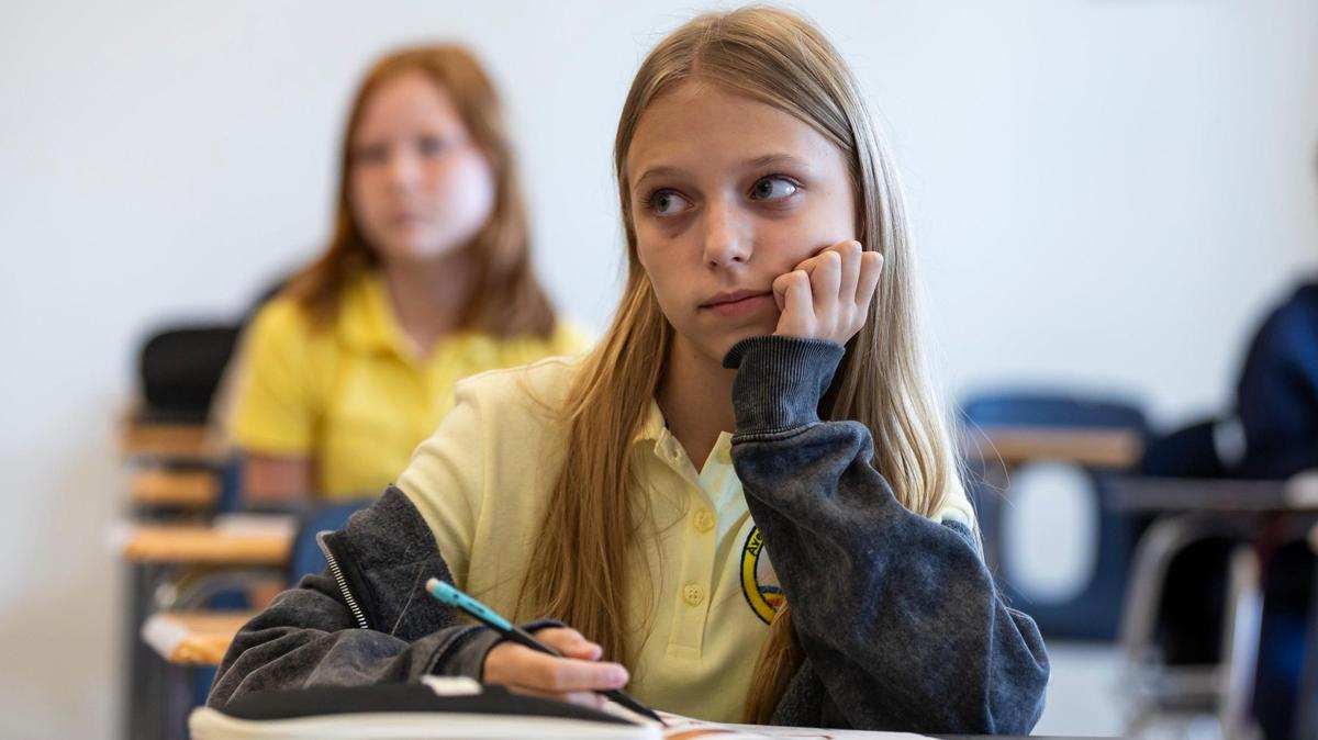 Alina Pohorilets, 11, a 6th grader from Ukraine, listens to her ESOL teacher, Arelys Morejon, while doing classwork at Aventura Waterways K8 Center on Thursday, Sept. 5, 2024, in Aventura, Fla.