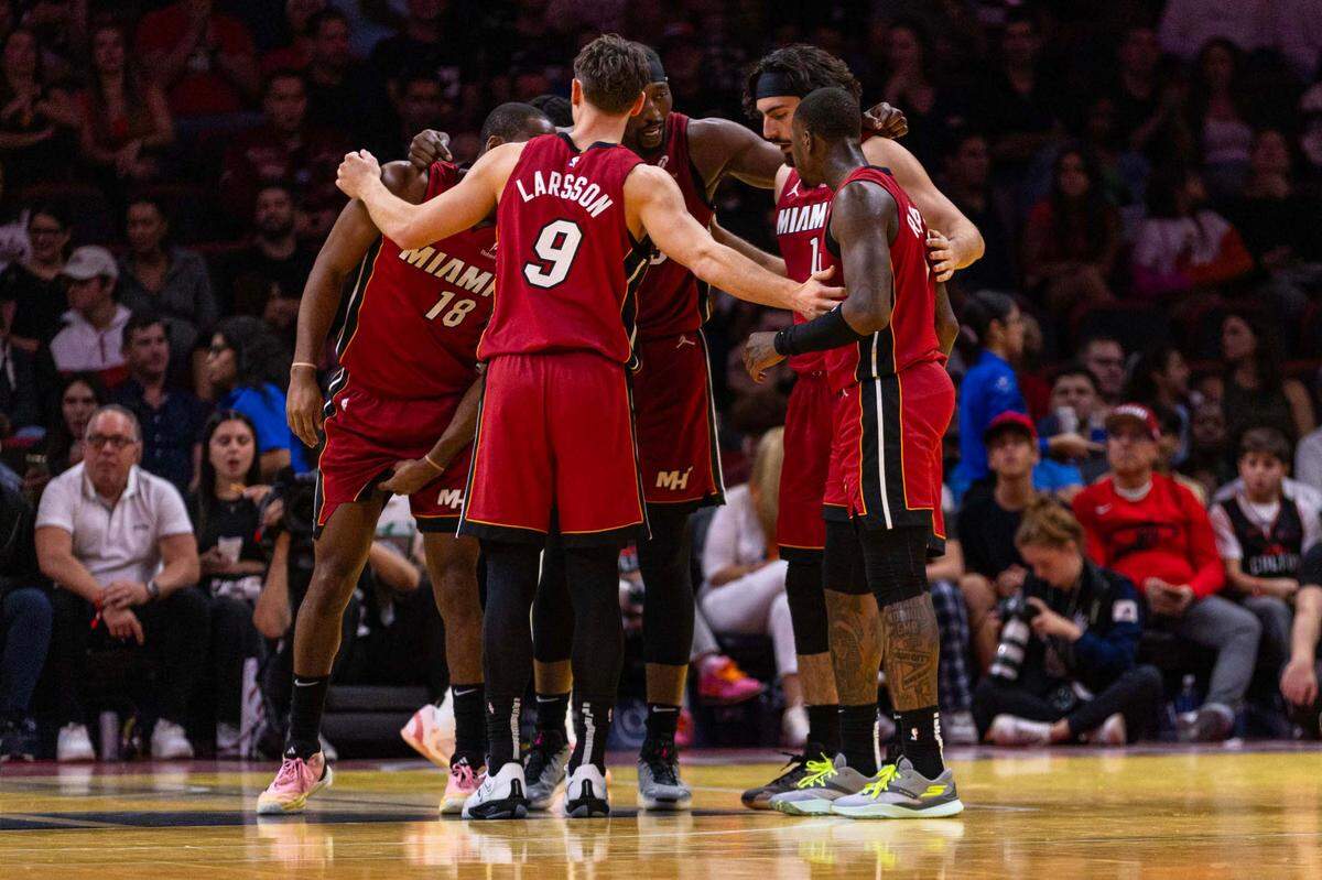 Miami Heat center Bam Adebayo (13) speaks to his teammates  Alec Burks (18), Pelle Larsson (9), Jaime Jaquez Jr. (11) and  Terry Rozier (2) while in a huddle during the first half of an NBA game against the Toronto Raptors at Kaseya Center on Friday, Nov. 29, 2024, in Miami, Fla