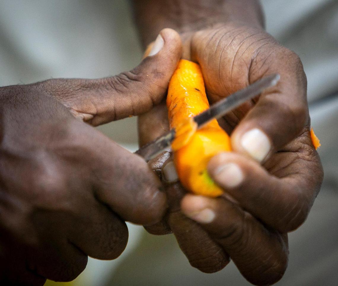 A man peels carrots at the World Central Kitchen in Les Cayes, where thousands of hot meals are prepared daily to feed victims of the August 14, 2021, earthquake.