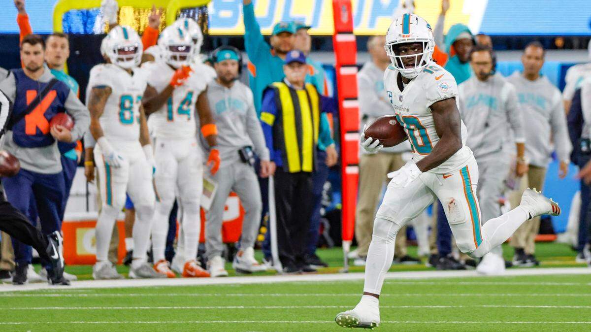 Miami Dolphins wide receiver Tyreek Hill (10) runs to score a touchdown after picking up a fumble by Miami Dolphins running back Jeff Wilson Jr. (23) in the second quarter during the game against the Los Angeles Chargers at SoFi Stadium in Inglewood, California on Sunday, December 11, 2022.