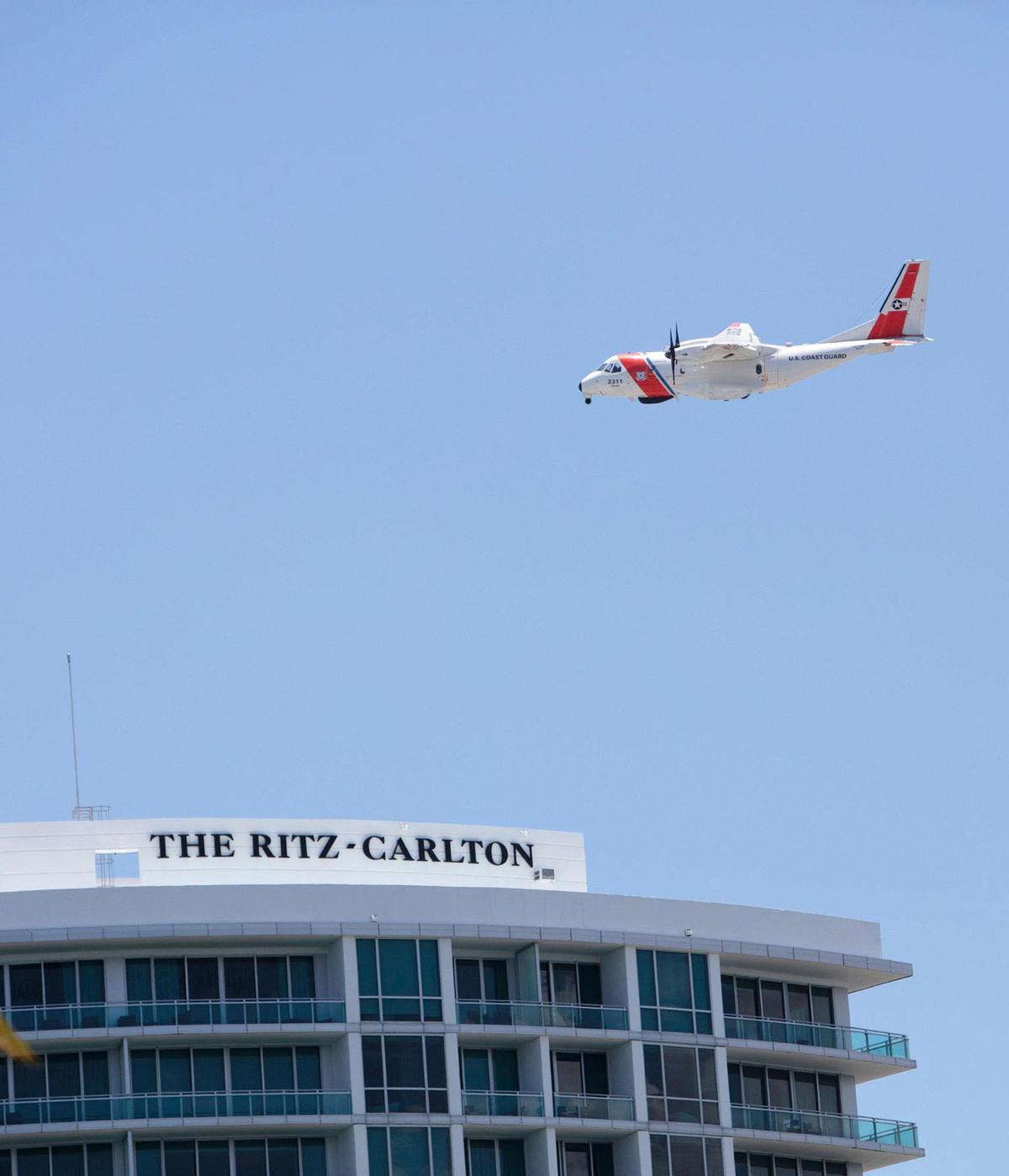 A U.S. Coast Guard plane circles an area around a Haulover bridge where a small plane crashed Saturday, May 14, 2022.