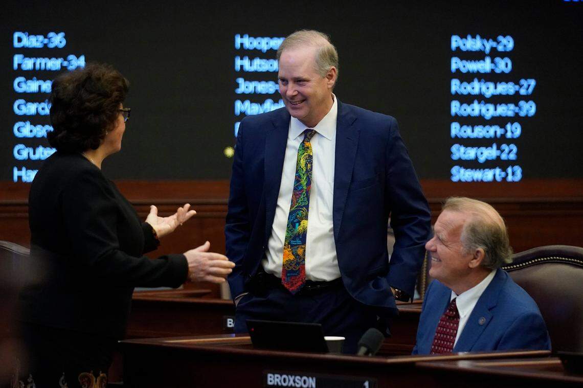 Florida Senators Kathleen Passidomo, left, and Doug Broxson, right, talk with Senate President Wilton Simpson during a legislative session at the Florida State Capitol, Thursday, March 10, 2022, in Tallahassee, Fla.