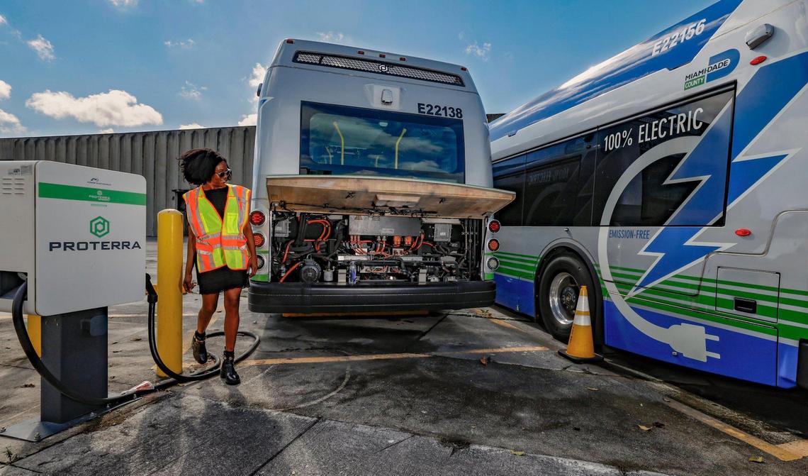 Deborah Souverain, Media and Public Relations Officer for Miami-Dade County Department of Transportation and Public Works, walks past broken electric Proterra buses parked at Miami-Dade County Coral Way Bus Maintenance Facility in Miami on Wednesday, February 19, 2025.