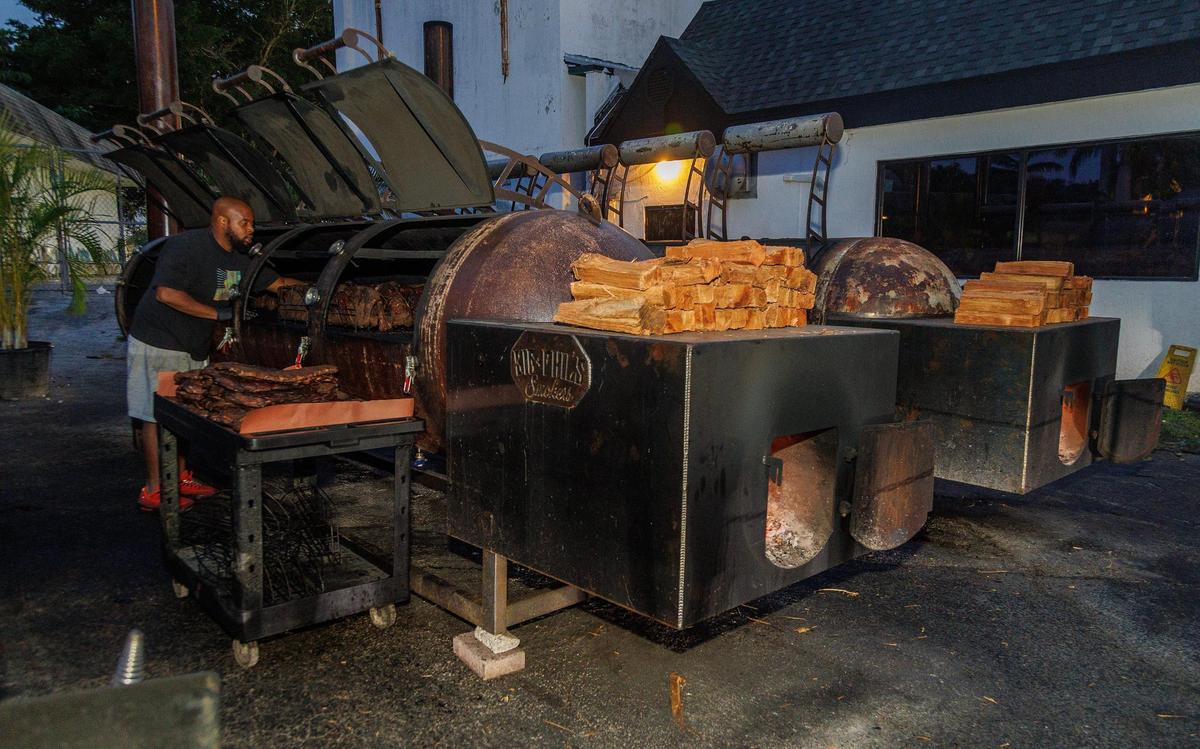 Aaron Jean Pierre, head pit master at Apocalypse BBQ, checks some briskets at the popular restaurant’s gigantic barbecue smokers.