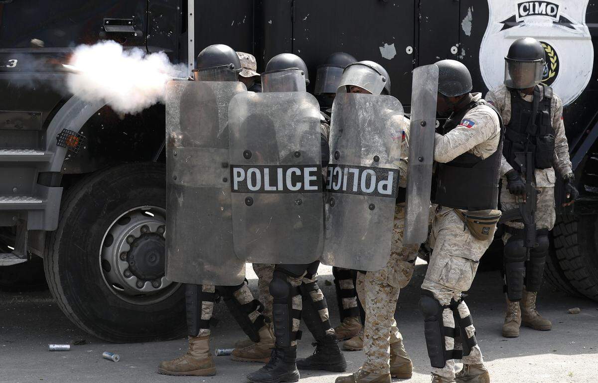 Police fire tear gas as they try to block anti-government protesters from reaching United Nations headquarters, in Port-au-Prince, Haiti, Friday, Oct. 4, 2019.