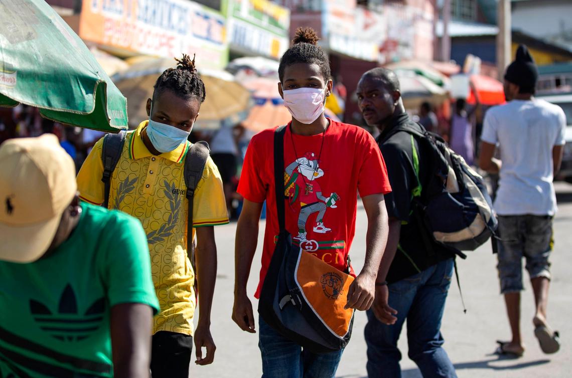 A couple of youths wearing masks to protect against the spread of the new coronavirus walk in the streets of Port-au-Prince, Haiti, on Monday, March 23, 2020.