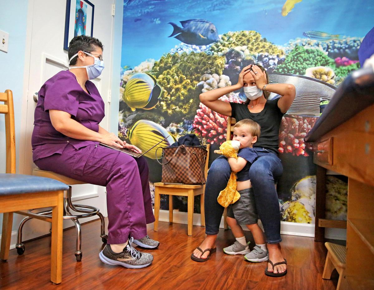 Dr. Keri Livingstone speaks with Stephanie Daniel during a check-up for 2-year-old son, George, about the challenges of balancing work, children and life events in the midst of the coronavirus pandemic.