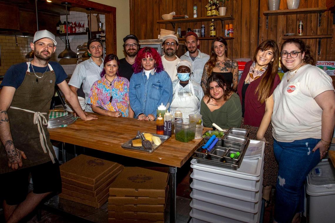 The staff gathers for a photo at Old Greg’s Pizza restaurant in Miami. The new establishment was rocked by building repairs, supply and staff shortages, and, of course, COVID-19.