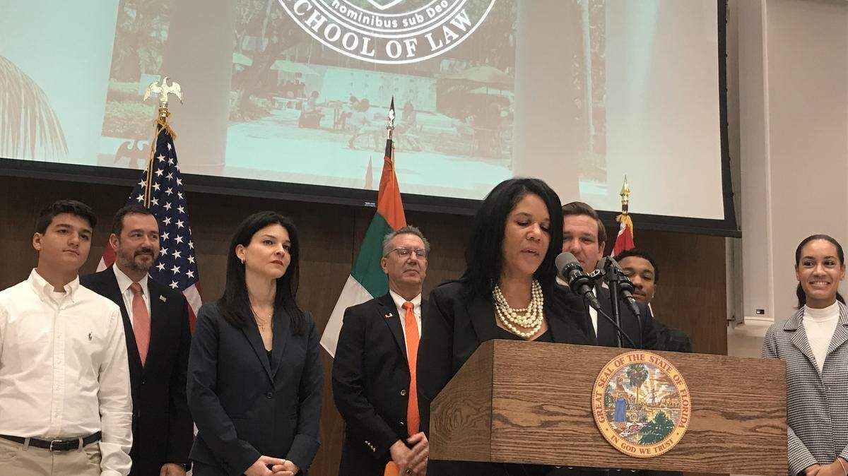 Tanya Brinkley talks to the press at the University of Miami Wednesday as Gov. Ron DeSantis, right, looks over her shoulder and Michelle Alvarez Barakat, left, listens. DeSantis appointed Brinkley and Barakat to the 11th judicial circuit.
