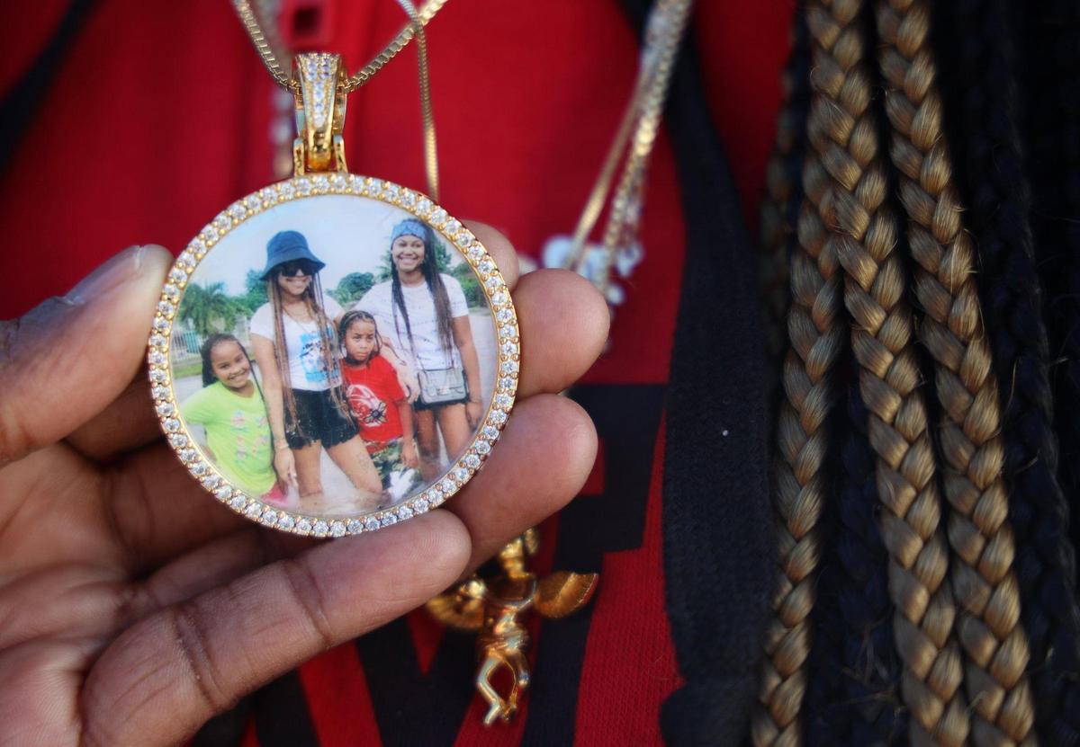 This medallion, which Ka’Mora McKenzie wears every day, shows her mother, Sally Aponte, who was killed in September by gun violence, along with Ka’Mora, right, and Aponte’s other surviving children, Ja’Dore Myles, 9, left, and Ja’Quevin Myles Jr., 8, second from the right.