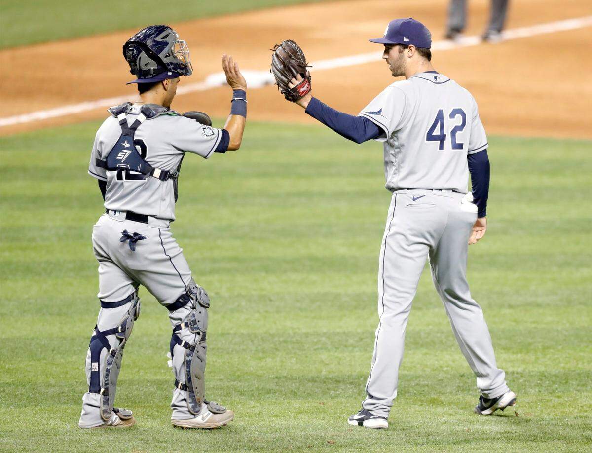 Tampa Bay Rays catcher Michael Perez (7) and Tampa Bay Rays relief pitcher John Curtiss (84) celebrate the win over the Miami Marlins at Marlins Park in Miami on Saturday, August 29, 2020.