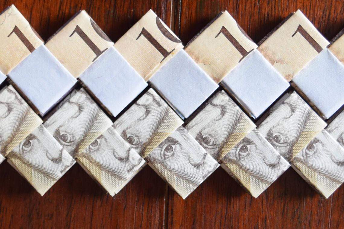 Venezuelan money is folded into strands that will be used to make handbags in Cúcuta, Colombia. As Venezuela’s bolivar has lost its value, artisans say it’s worth more as a raw material than as a currency.