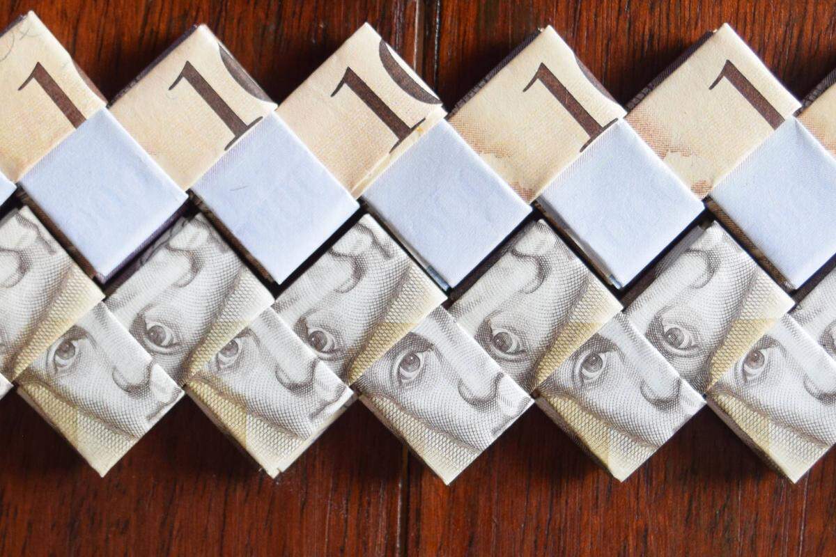 Venezuelan money is folded into strands that will be used to make handbags in Cúcuta, Colombia. As Venezuela’s bolivar has lost its value, artisans say it’s worth more as a raw material than as a currency.