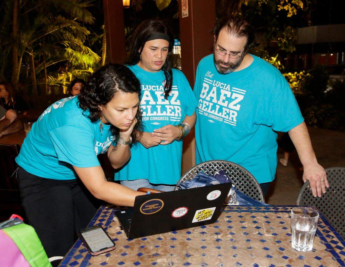 U.S. Congressional District 27 Democratic candidate, educator and community leader Lucia Baez-Geller (center) , her hucband David and Voter Engagement Director Kristellys Estanga check the election results during election night party on Tuesday, November 5, 2024 at Casa Cubana in South Miami. Andrew Uloza / for Miami Herald