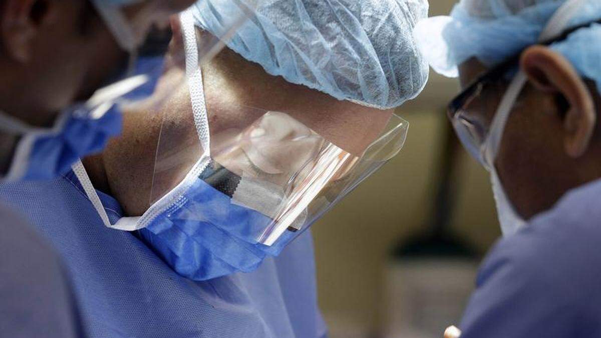 In this 2014 photo, trauma surgeon Dr. Jared Bernard helps perform surgery on a gunshot victim.