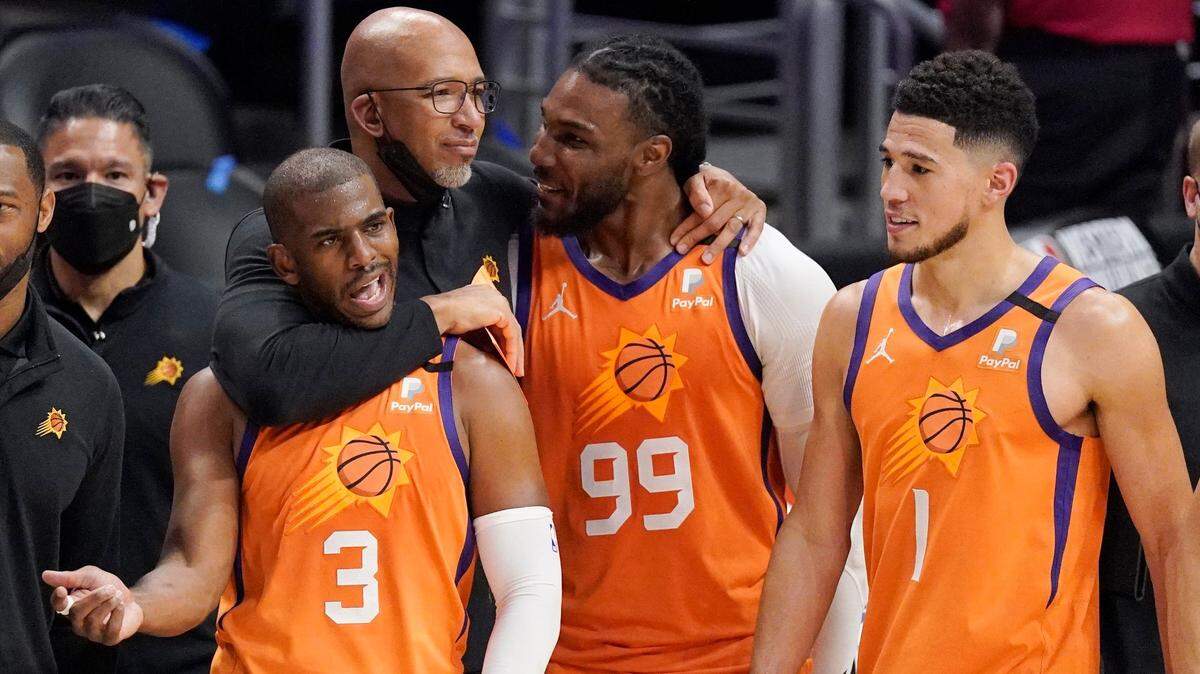 El entrenador de los Suns, Monty Williams abraza a Chris Paul (3) y a Jae Crowder (99), junto a Devin Booker en el Juego 6 de las finales de la Conferencia Oeste contra los Clippers, el 30 de junio de 2021, en Los Ángeles.