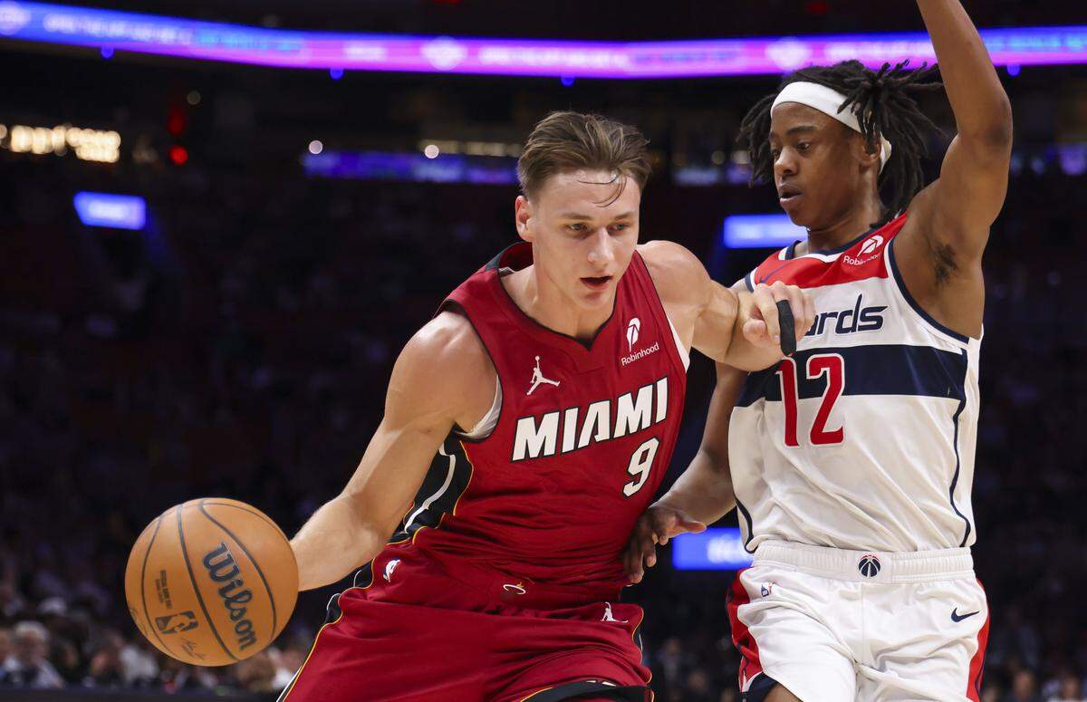 Miami Heat guard Pelle Larsson (9) drives the ball against Washington Wizards guard Tre Johnson (12) during the first half of a basketball game on March 10, 2026, at Kaseya Center in Miami.