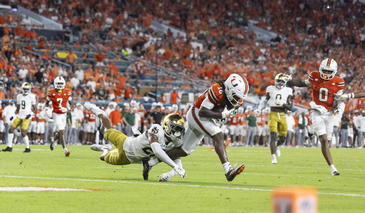 Miami Hurricanes wide receiver Malachi Toney (10) catches a pass as Notre Dame Fighting Irish cornerback Karson Hobbs (21) defends in the first half of their NCAA football game at Hard Rock Stadium on Sunday, Aug. 31, 2025, in Miami Gardens, Fla.