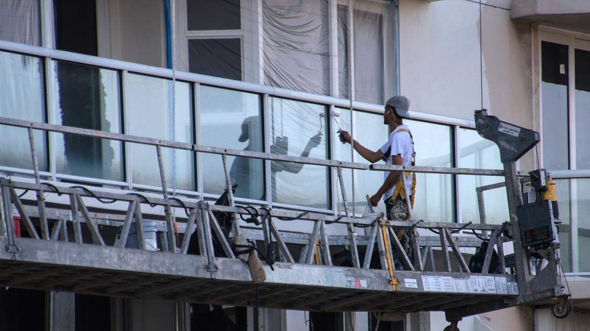 Workers repair the exterior of a South Florida condo building in 2021.