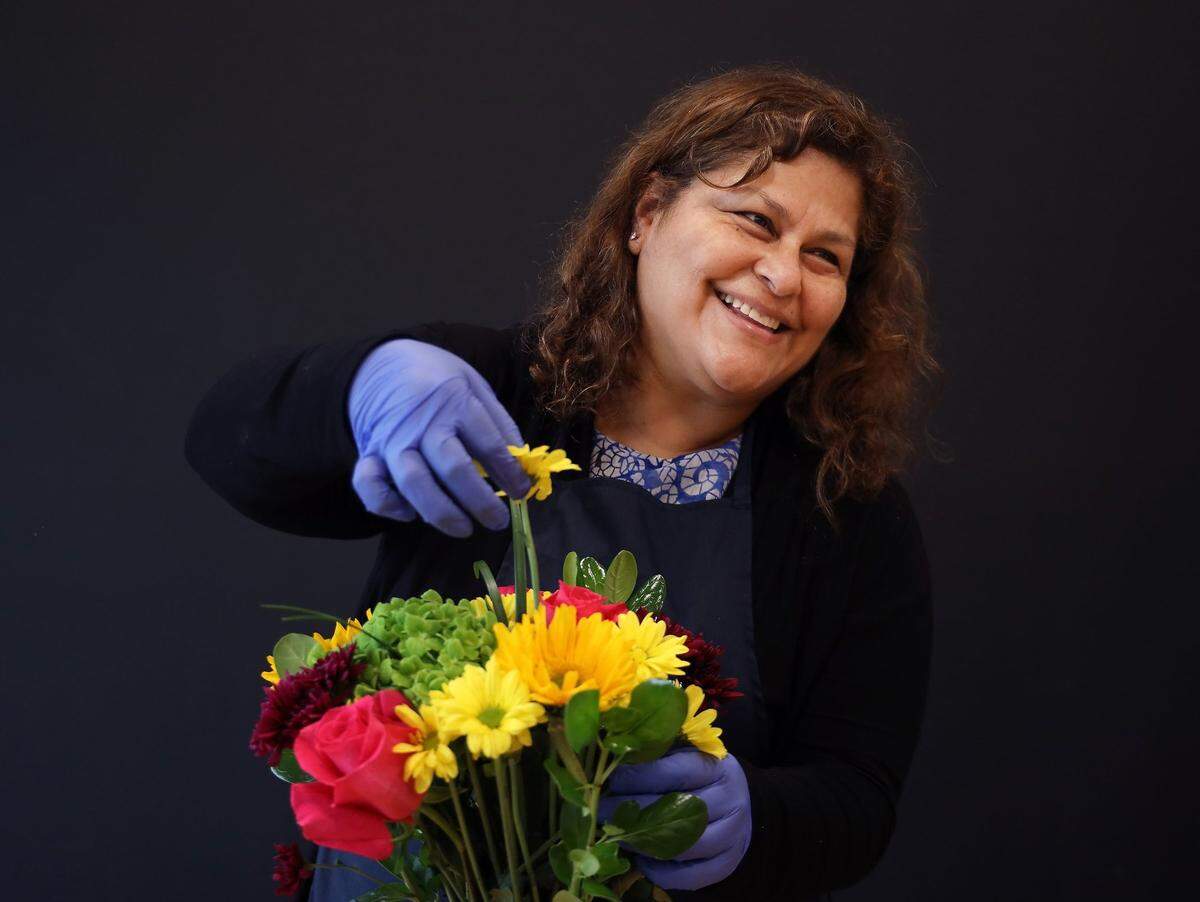 Jacqueline Cordova, coordinator of samples, puts together a floral arrangement at Galleria Farms, a cut-flower importer and wholesaler that is a client for Professional Bank.