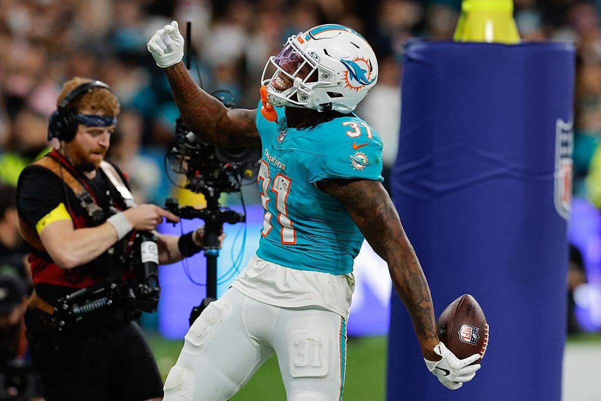 Miami Dolphins' running back #31 Ollie Gordon II  celebrates with teammates after scoring a touchdown to tie the game during the NFL match between Miami Dolphins and Washington Commanders at Santiago Bernabeu Stadium in Madrid on November 16, 2025. (Photo by Oscar DEL POZO / AFP) (Photo by OSCAR DEL POZO/AFP via Getty Images)          