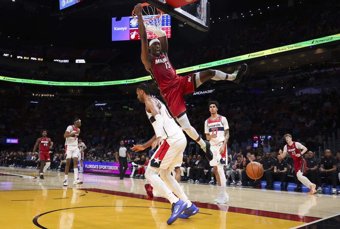 Miami Heat center Bam Adebayo (13) dunks the basketball over Washington Wizards center Alex Sarr (20) during the first half of a basketball game on Tuesday, March 10, 2026, at Kaseya Center in downtown Miami, Fla. 