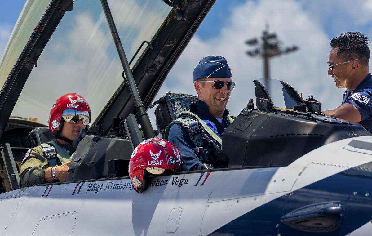 Sovan Din (far right), dedicated crew chief, finalizes details with Maj. Samuel “RaZZ” Larson and NFL star Jimmy Graham, who is flying as a civilian passenger in the backseat of a Thunderbirds F-16 Fighting Falcon, during a practice flight ahead of the Hyundai Air & Sea Show over Memorial Day weekend.