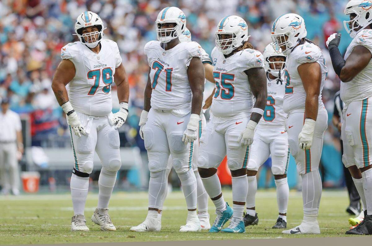 Miami Dolphins offensive tackle Larry Borom (79), offensive tackle Kion Smith (71), guard Aaron Brewer (55), and guard Jonah Savaiinaea (72) approches the line of scrimmage during their NFL football game against the New England Patriots at Hard Rock Stadium in Miami Gardens, Florida, on Sunday, September 14, 2025. 