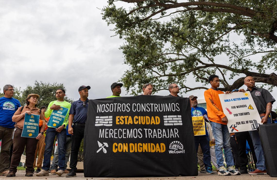 Construction workers hold signs as they listen to speakers during a WeCount! press conference outside Government Center on Wednesday, Oct. 16, 2024, in downtown Miami, Fla.