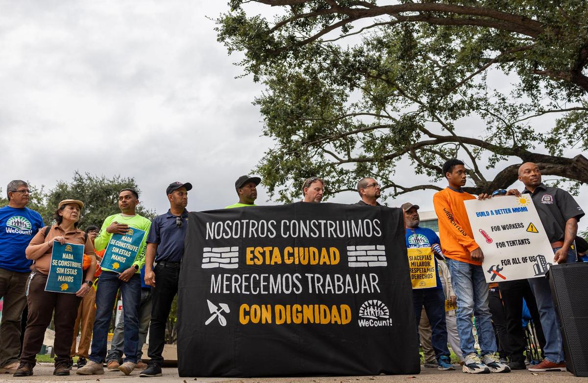 Los trabajadores de la construcción sostienen carteles mientras escuchan a los oradores durante una conferencia de prensa afuera del Centro de Gobierno el miércoles 16 de octubre de 2024, en el centro de Miami, Florida. La conferencia de prensa fue organizada por WeCount, un grupo de defensa que organiza a los trabajadores al aire libre, que pide mejores condiciones de trabajo, salarios más altos y beneficios de salud para los trabajadores de la construcción.