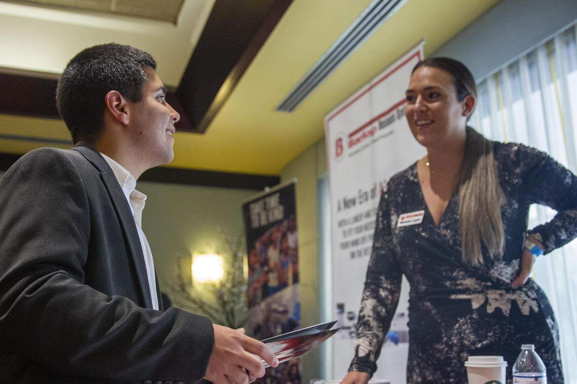 Marketing representative for Barlop Business Systems, Michele Lopez, right, asks Andre Cama why he is interested in working sales during a job fair at Shula’s Hotel and Golf Club in Miami Lakes, Florida, on Wednesday, July 10, 2019.