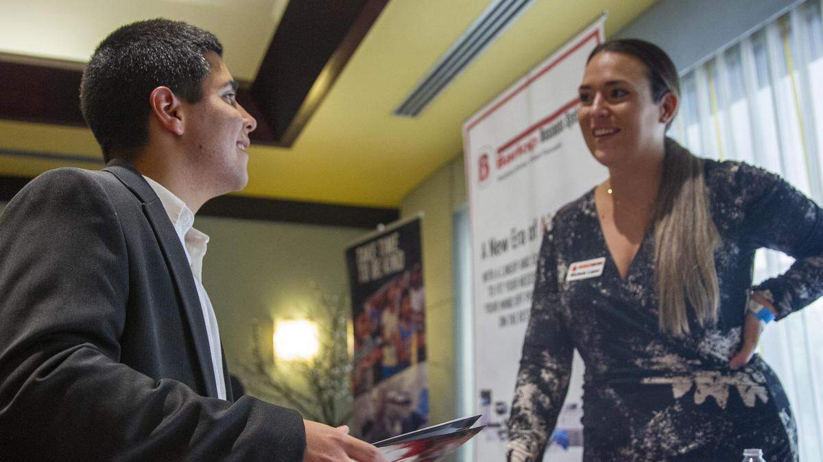 A marketing representative for Barlop Business Systems, Michele Lopez, right, asks Andre Cama why he is interested in sales during a job fair at Shula’s Hotel and Golf Club in Miami Lakes, Florida, on Wednesday, July 10, 2019.
