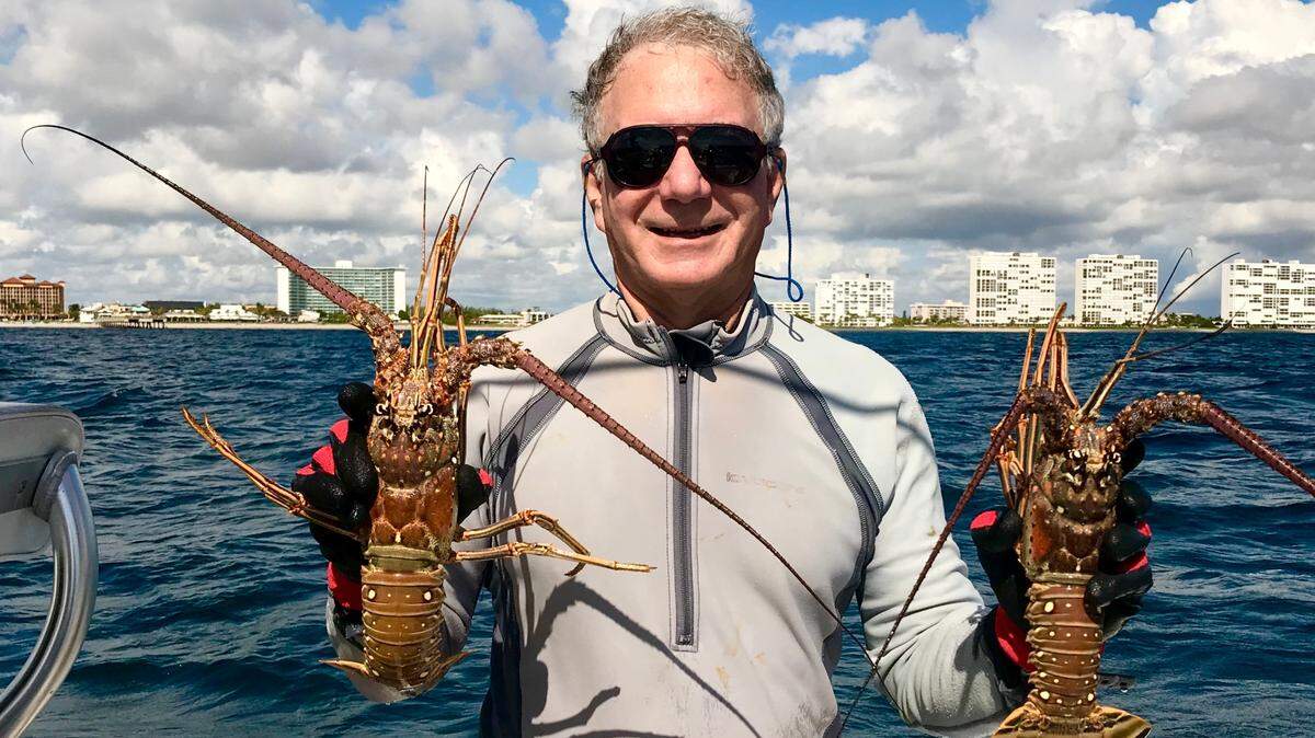 ER physician Dr. Jack Harari of Fort Lauderdale shows off two nice lobsters that he caught while diving off Deerfield Beach on Jim ‘Chiefy’ Mathie’s boat.