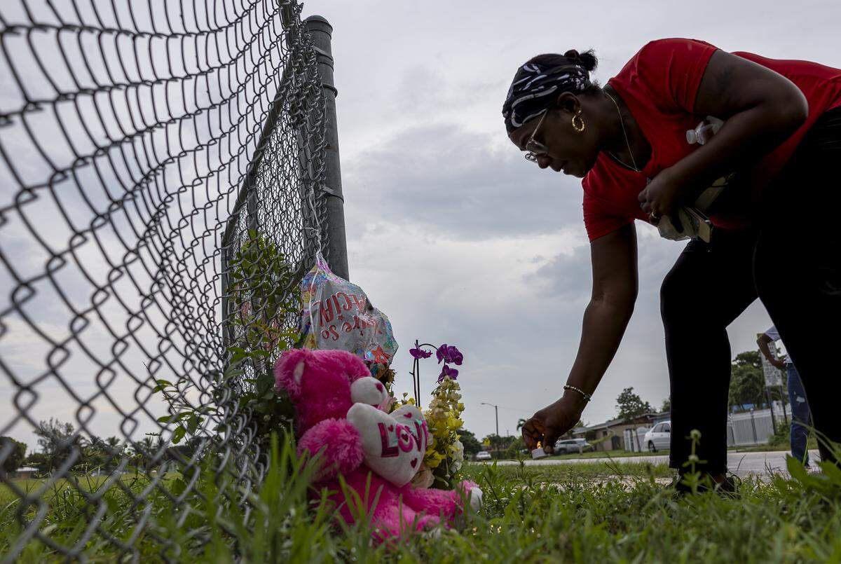 Wylisa Haskins places a lighted plastic candle at a makeshift memorial for the late Doreen Richards Broadbelt, 71, who police said was walking to her job at Walmart when a dog attacked and fatally mauled her near her home on Labor Day. A vigil was held nearby at Broadbelt's home on Tuesday, Sept. 9, 2025, in Miami Gardens, Fla.