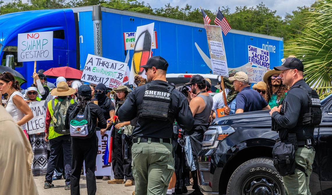 Law enforcement officers seen as a group of people protested against the visit of US President President Donald Trump and Florida Governor Ron DeSantis, while they toured the migrant detention center, dubbed “Alligator Alcatraz,” located at the site of the Dade-Collier Training and Transition Airport in Ochopee, Florida on July 1, 2025.