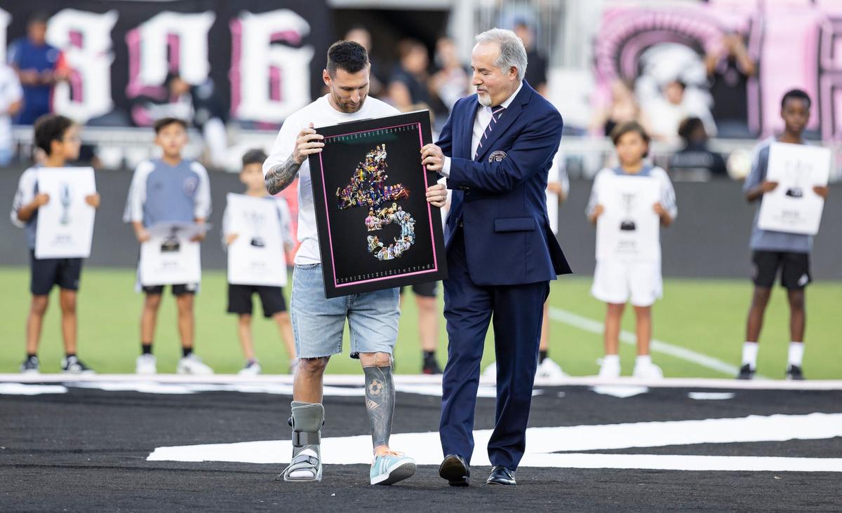 Inter Miami forward Lionel Messi, wearing a walking boot on his injured right foot, is recognized for winning 45 titles throughout his career by Inter Miami co-owner Jorge Mas during a ceremony before their team’s MLS match against Chicago Fire at Chase Stadium on Saturday, July 20, 2024, in Fort Lauderdale, Fla.