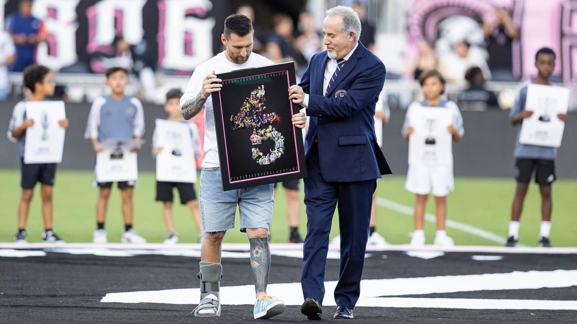 Inter Miami forward Lionel Messi, wearing a walking boot on his injured right foot, is recognized for winning 45 titles throughout his career by Inter Miami co-owner Jorge Mas during a ceremony before their team’s MLS match against Chicago Fire at Chase Stadium on Saturday, July 20, 2024, in Fort Lauderdale, Fla.