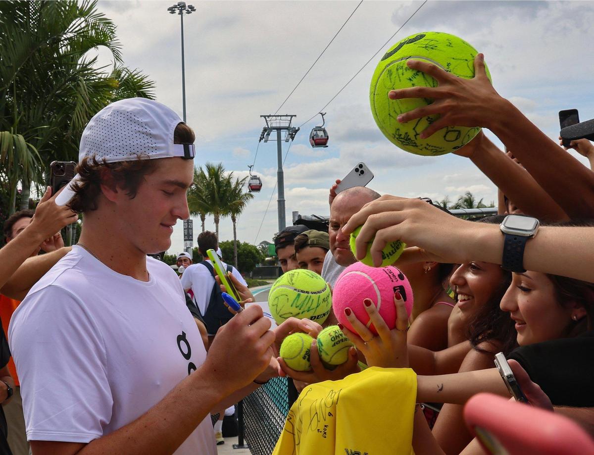 Brazilian tennis player Joao Fonseca, left, signs autographs for his fans who waited to get a glimpse, his signature, and maybe a photo of the popular tennis player as he exited practice on Court 20 during the Miami Open at Hard Rock Stadium in Miami Gardens, Florida, on Sunday, March 23, 2025.
