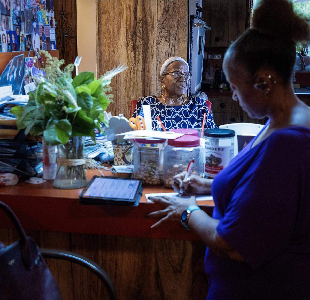 Thelma Vernell Anderson Gibson, left, the cherished icon of Coconut Grove, is celebrating her 99th birthday this month and continues to be steward of beyond the Grove as she is photographed in her kitchen of her home where she has a view of family photos and other memorabilia as while her niece Alvetia Anderson, right, stop by for a visit on Tuesday, December 10, 2025, in Miami, Florida. Gibson's groundbreaking contributions to the community as a dedicated educator and an advocate for civil rights, Gibson played a vital role in promoting social justice and equality. She was instrumental in establishing programs that empowered youth and fostered cultural awareness. Her legacy is marked by her unwavering commitment to uplifting her community, making her a beloved figure whose impact continues to inspire future generations.