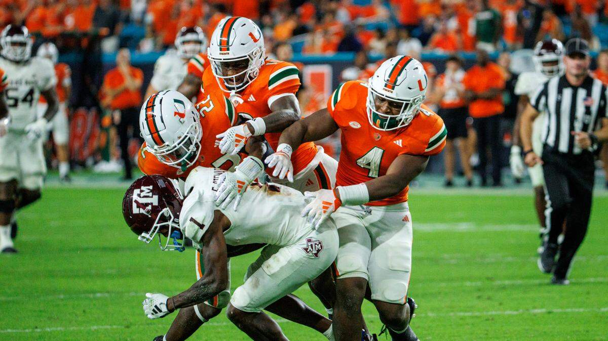 Miami Hurricanes defensive back Jaden Davis (22) Hurricanes defensive back Jaden Harris (19) and Hurricanes linebacker Keontra Smith (4) tacklet Texas A&M Aggies wide receiver Evan Stewart (1) during the fourth quarter of an NCAA non conference game at Hard Rock Stadium on Saturday, Sept. 9, 2023 in Miami Gardens, Florida.