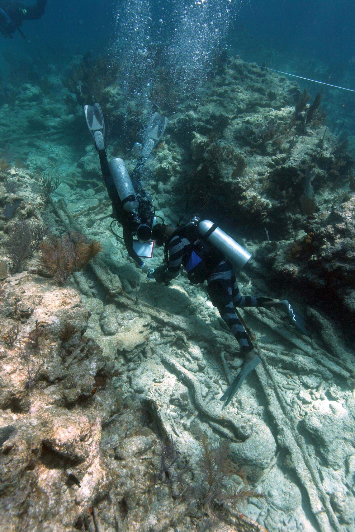 A dive team examines fragments of the sunken vessel’s iron framing on Molasses Reef off Key Largo, Friday, June 9, 2018.