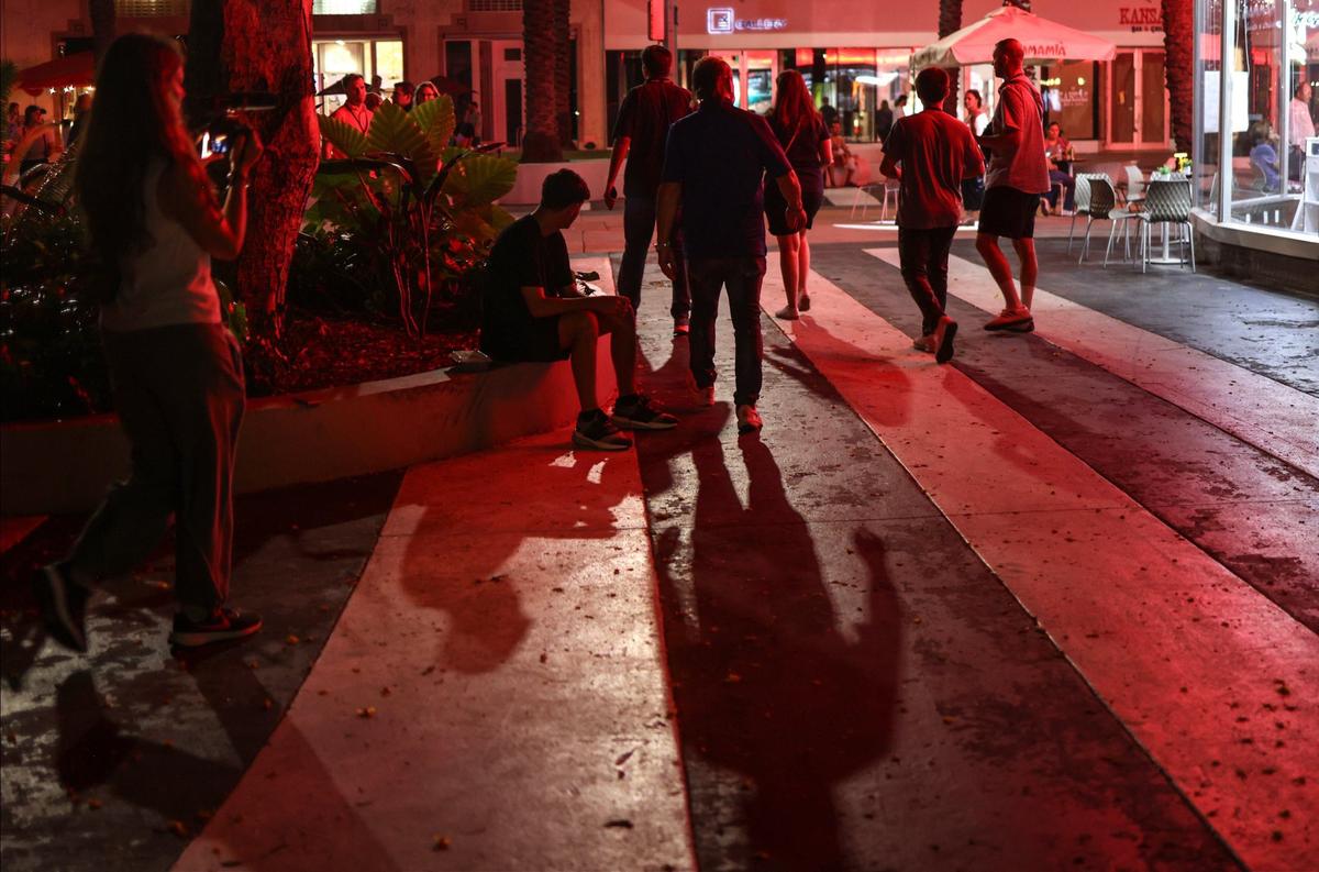 A homeless canvassing team exits a dark section of Lincoln Road Mall on Thursday, Aug. 22, 2024, in Miami Beach while attempting to count the unsheltered population.