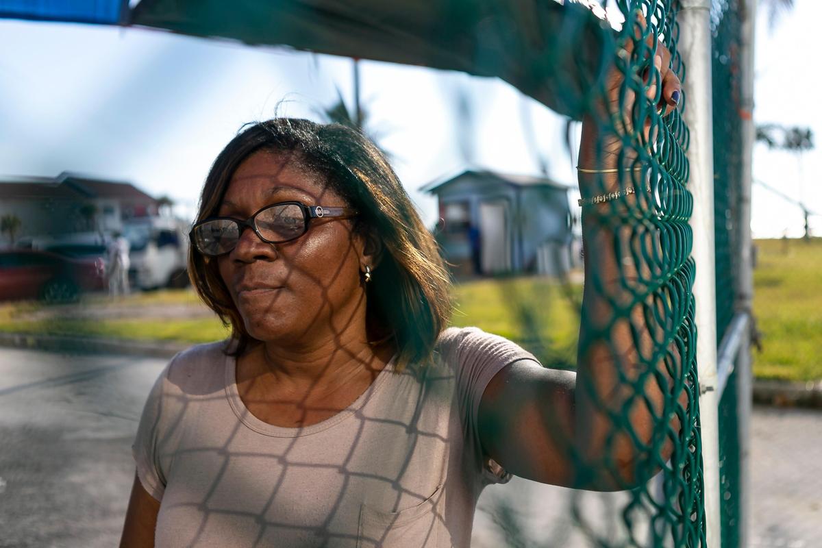 Florence Dean, 53, watches passengers board the Grand Celebration cruise ship as she waits for her daughter to clear customs at Freeport Harbor in Grand Bahama Island on Friday, September 6, 2019.