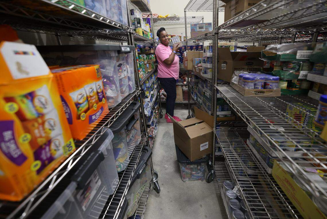 Employee Iona Sawyer stocks the shelves in the pantry of the Lotus House Children's Village as the facility prepares to serve its clients and members of the surrounding community. Lotus Hour executive director Isabella Dell'Oca gave a tour of the newly built 70,000 square foot Children's Village, where 14 nonprofits focus on the education, health, and therapeutic needs of children of Lotus House clients and members of the surrounding community on Thursday, November 13, 2025, in Miami, Florida.