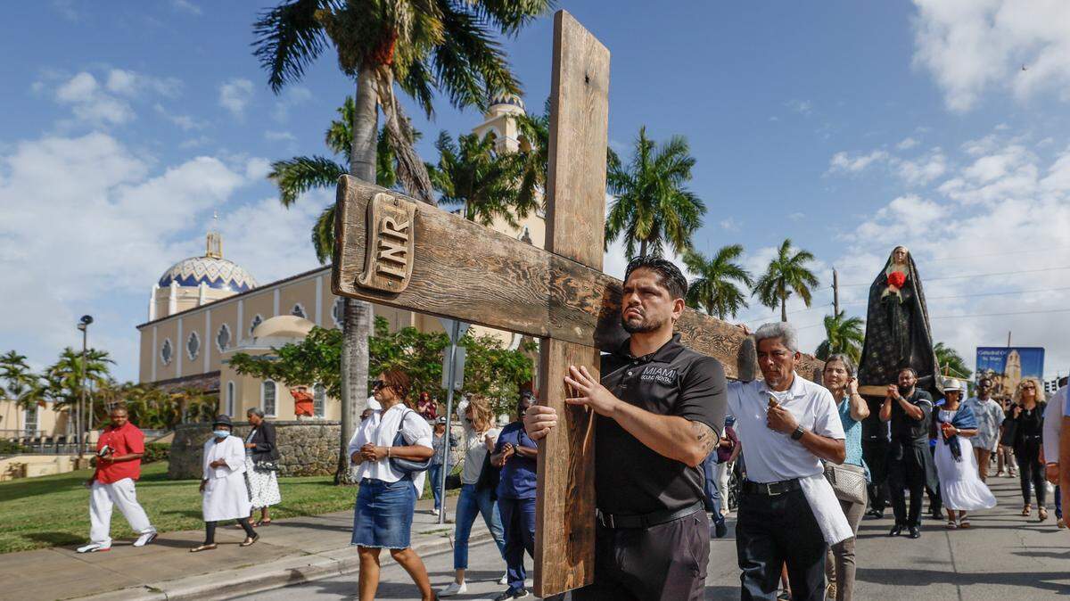 Mario Moreno, front, Walner Hernandez, center, and Melfy Mesa carry the cross during the Stations of the Cross procession on Friday, April 3, 2026, in Miami.