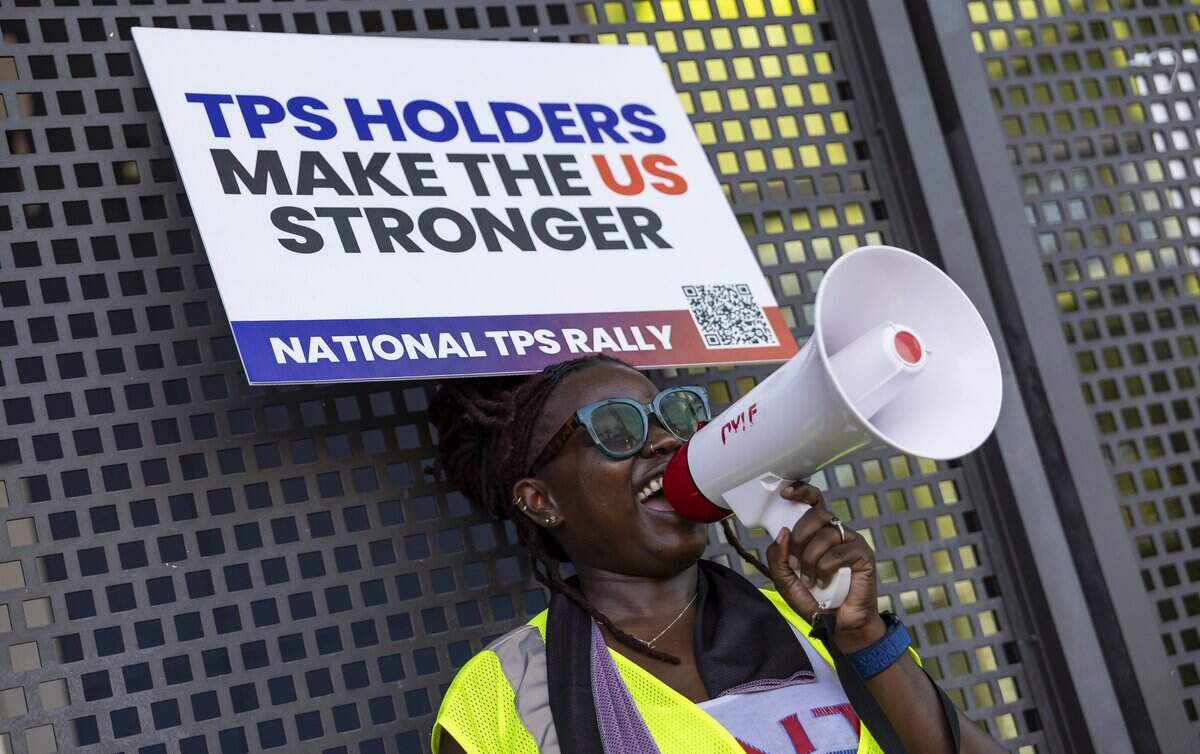 Ketia Pierre-Bruno uses a megaphone during a rally at the Little Haiti Cultural Center on Thursday, July 9, 2026, in Miami, Fla. The event called for protections for Temporary Protected Status (TPS) holders and other immigrants after the Trump administration stripped many of them of legal protections against deportation.