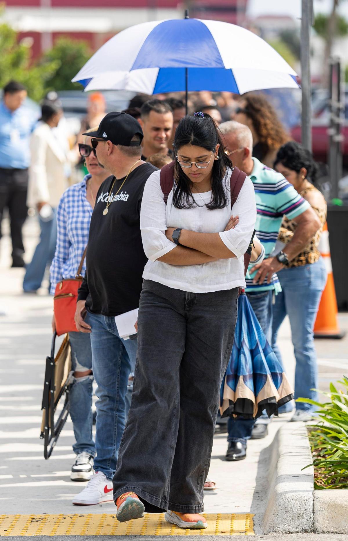 Brenda Caro, center, who did not have an appointment, waits in line outside the Miami Central DMV office for a chance to get her first driver’s license on Wednesday, April 16, 2025, in Miami. Caro had been standing in line for more than three hours for a chance to be let inside the center.