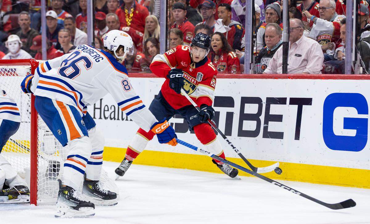 Florida Panthers center Anton Lundell (15) passes the puck as Edmonton Oilers defenseman Philip Broberg (86) defends in the third period of Game 7 of the Stanley Cup Final at Amerant Bank Arena on Monday, June 24, 2024, in Sunrise, Fla.