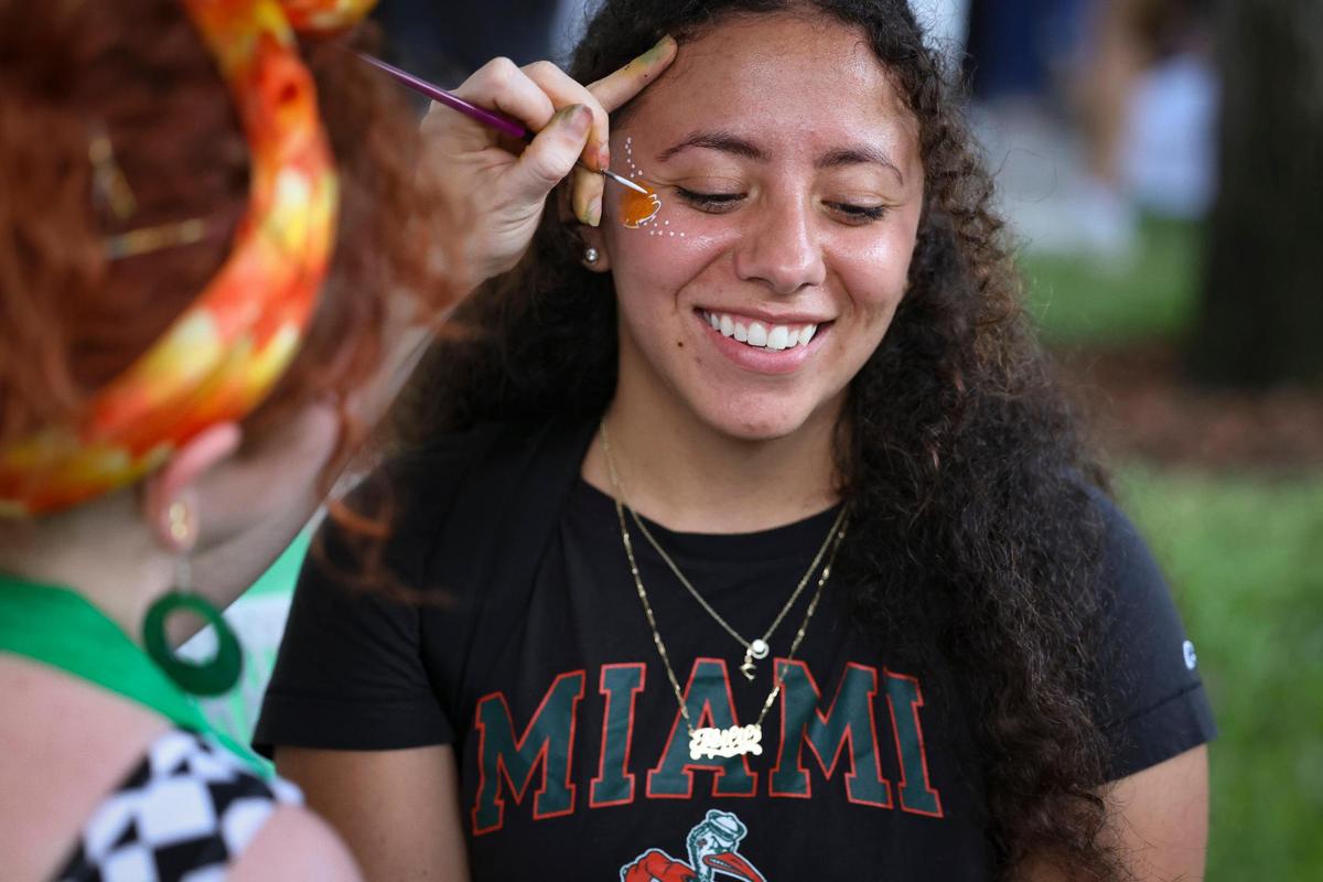Teilil Garcia-Gonzalez, current student, smiles while getting a Hurricanes-colored seashell painted on her face during the University of Miami Centennial celebration on Tuesday, April 8, 2025, outside on Foote University Green at the University of Miami’s Coral Gables campus.